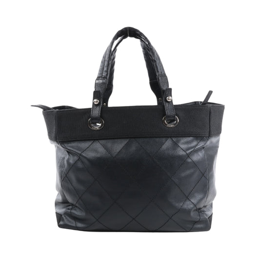 Black quilted handbag on a white background