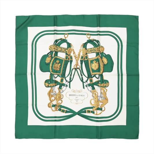 Hermès Carré 90 "BRIDES de GALA" silk handkerchief in green, showcasing a symmetrical design of two ornate gold and green bridles with intricate detailing, centered on a white background with green borders, printed on luxurious silk.