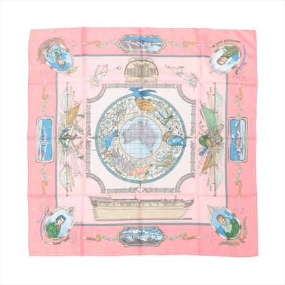 Hermès Carré 90 "LE GEOGRAPHE" silk handkerchief in pink featuring a detailed world map centered on Australia, surrounded by vintage-style illustrations of birds, ships, historical portraits, and geographic motifs, printed on smooth, high-quality silk.