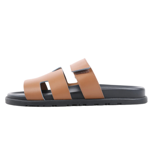 Tan sandal with black sole on a white background