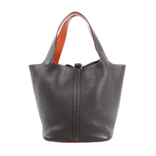 Dark gray leather handbag with orange interior lining on a white background
