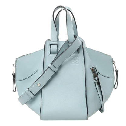 Front view of LOEWE Hammock Small Leather 2Way Handbag in light blue smooth leather with top handles, side zip details, and adjustable shoulder strap, displayed against a white background.
