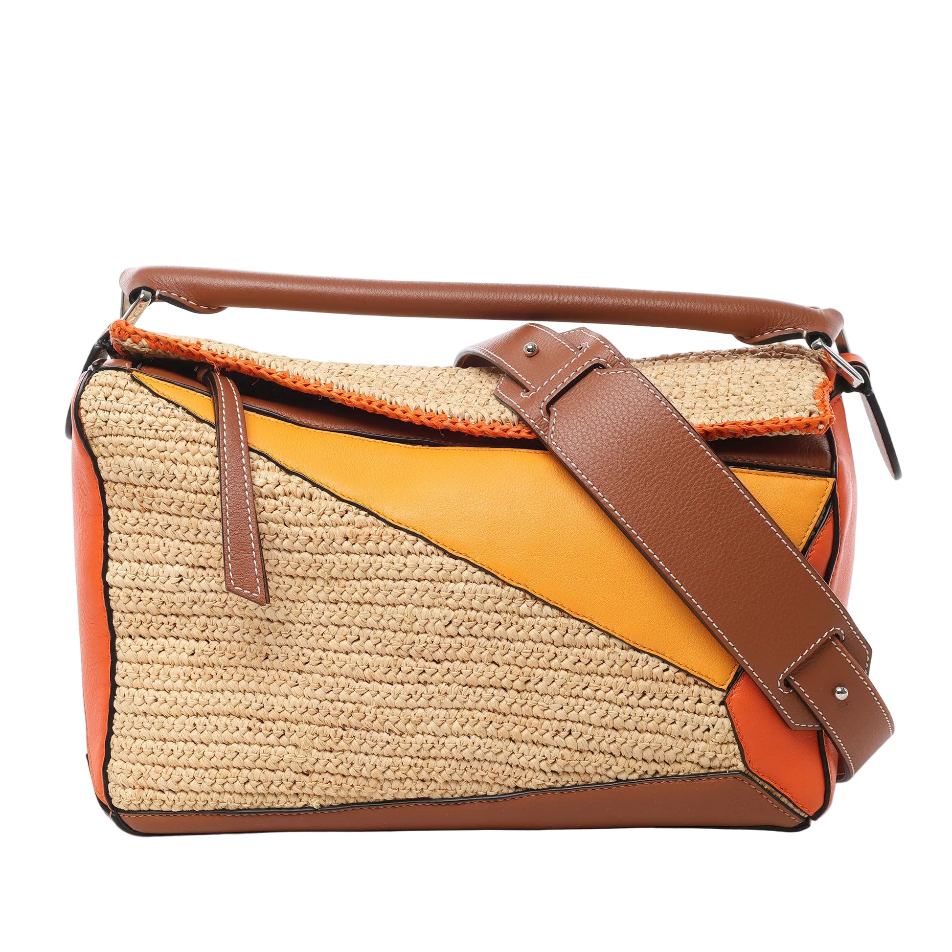 Front view of LOEWE Puzzle Medium Raffa and Leather 2Way Handbag in orange, brown, and beige, featuring geometric panel design with woven raffia sections, smooth leather accents, top handle, and wide adjustable shoulder strap against a white background.