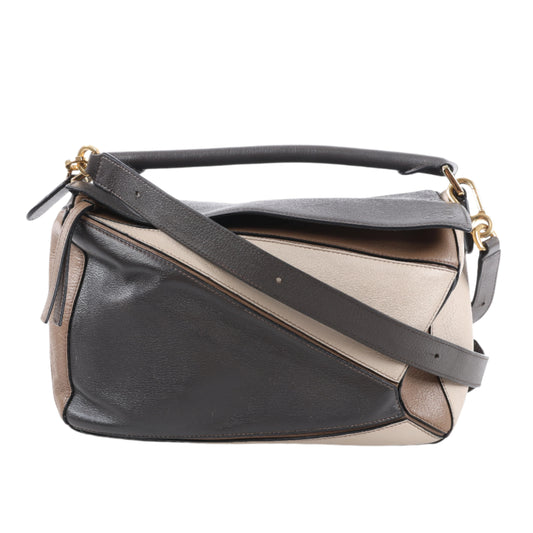 Two-tone handbag with black and beige sections on a white background