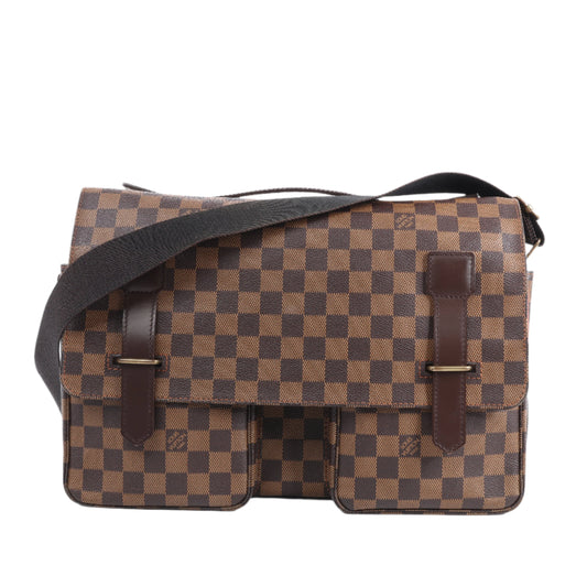 Brown checkered bag with black strap on a white background