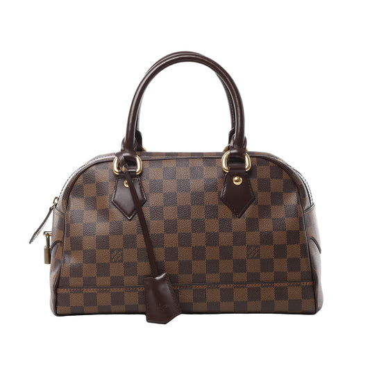 Front view of the Louis Vuitton Damier Ebene Duomo Handbag N60008, featuring signature brown checkerboard canvas, dark brown leather handles and trim, gold-tone hardware, a leather clochette, and a secure top zipper closure.