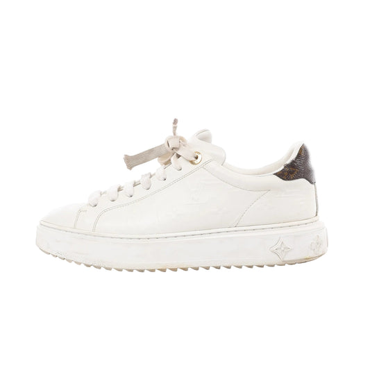 Side view of Louis Vuitton Time Out Sneakers in white leather, size 38 EU, featuring embossed LV monogram pattern, gold-tone eyelets, white laces, thick sole with monogram flower detail, and brown monogram heel accent against a white background.
