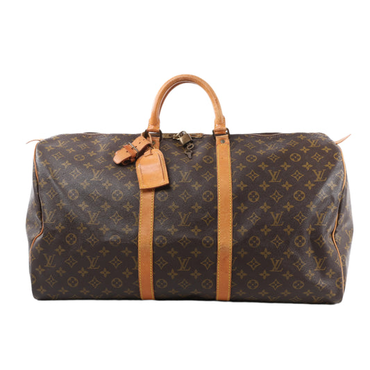 Brown travel bag with tan leather straps and handle on a white background