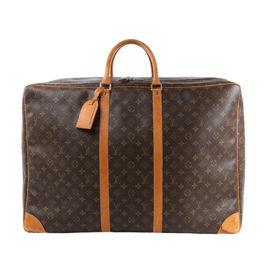 Brown suitcase with tan leather handles and corners on a white background