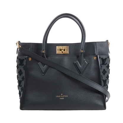 Black handbag with gold accents on a white background