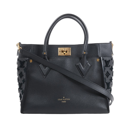Black handbag with gold accents on a white background