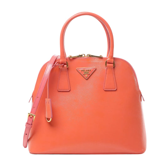 Front view of Prada Saffiano Vernice Dome Leather 2Way Handbag BL0909 in glossy begonia pink leather with gold-tone logo plaque, dual top handles, and detachable shoulder strap, displayed against a white background.
