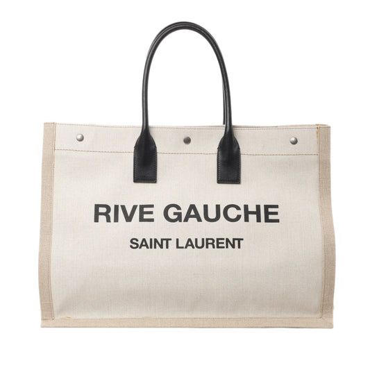 Front view of Saint Laurent Rive Gauche Large Tote Bag 499290 in beige canvas with black printed logo text, black leather top handles, and silver-tone hardware, displayed against a white background.