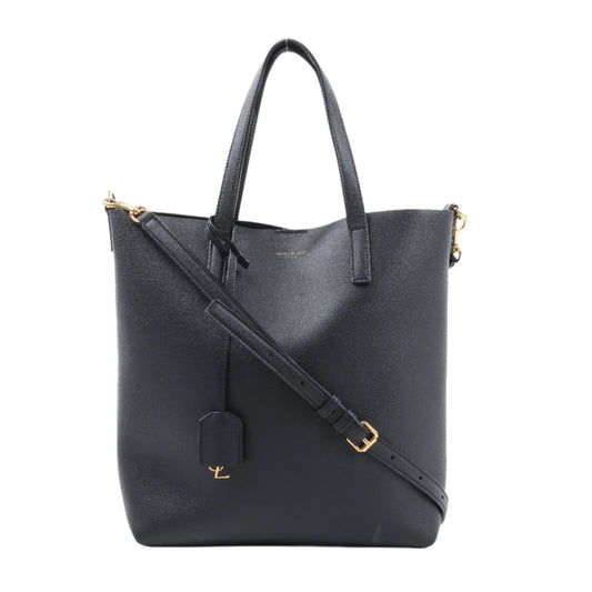 Black leather tote bag with gold accents on a white background