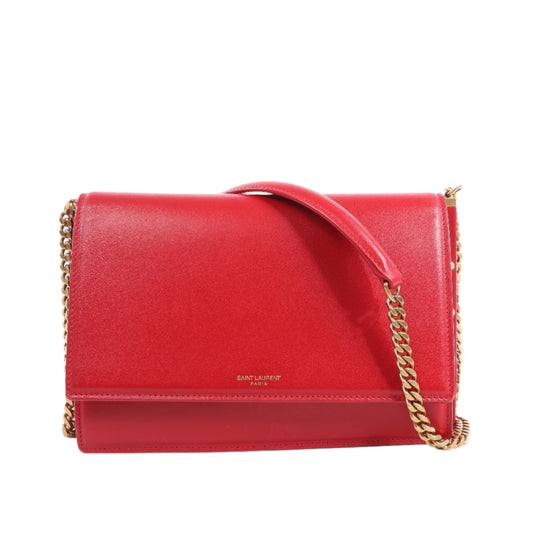Red handbag with gold chain strap on a white background